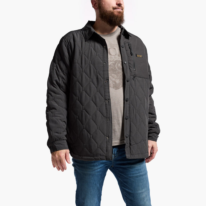 Man wearing a quilted jacket with a brand logo on a white background