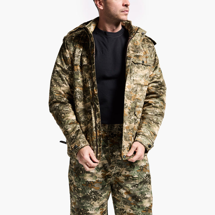 Person wearing a camouflage jacket and pants on a white background